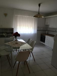 ザラカロシュにあるLívia Apartman - Zalakarosのキッチン(ガラステーブル、椅子付)、ダイニングルーム