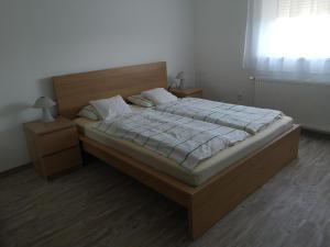 ザラカロシュにあるLívia Apartman - Zalakarosのベッドルーム1室(大型ベッド1台、木製ヘッドボード付)