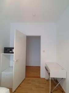 布伦迪欧斯Riverside Hostel的白色的客房设有书桌和门