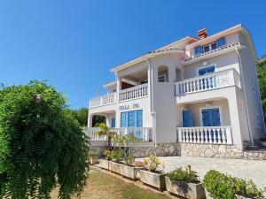 a large white house with a balcony at Apartments Villa Iva in Ravni