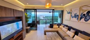 a living room with a couch and a flat screen tv at Departamento de lujo con playa privada Acapulco Diamante in Acapulco
