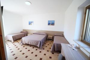 a hospital room with three beds and a window at Petracuzza casa vacanze in Tortora