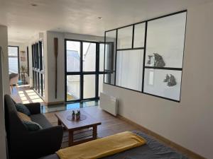 a living room with a couch and a table at Maison bois Port-Louis in Port-Louis +4 photos