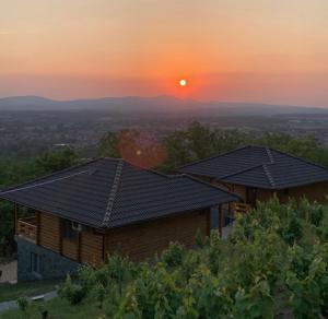 ein Haus auf einem Hügel mit Sonnenuntergang im Hintergrund in der Unterkunft Boja Zalaska 2 in Jagodina