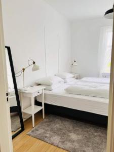 a white bedroom with a bed and a desk at Riverside Hostel in Blönduós