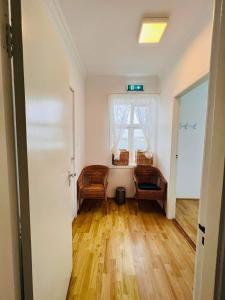 an empty room with two chairs and a window at Riverside Hostel in Blönduós