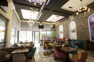 un ristorante con tavoli, sedie e finestre di B H B Apartmani a Novi Pazar
