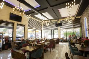 a restaurant with tables and chairs and windows at B H B Apartmani in Novi Pazar