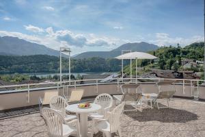 un patio con sillas, una mesa y una sombrilla en Bellavista Relax Hotel en Levico Terme