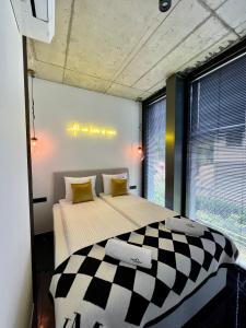 a bedroom with a large bed with a checkered blanket at NEON APARTMENTS in Sopot