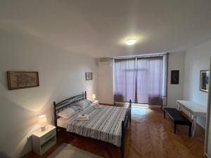 una camera da letto con un letto, una finestra e una scrivania di Apartmani Grand Market a Sarajevo