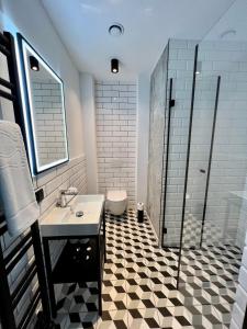 La salle de bains est pourvue d'un sol en damier noir et blanc. dans l'établissement NEON APARTMENTS, à Sopot