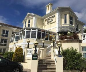 a large white building with a car parked in front of it at The Heritage Hotel in Torquay