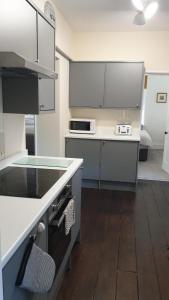 een keuken met witte kasten en een aanrecht bij Beautiful Garden Apartment in Leafy St Leonards 5 Mins to Beach in St. Leonards