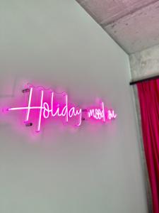 a neon sign that says holiday must be at NEON APARTMENTS in Sopot