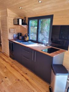 eine Küche in einem winzigen Haus mit einer Arbeitsplatte in der Unterkunft Roulotte Escapade nature à Morainville in Morainville-près-Lieurey