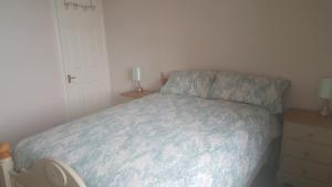 a small bedroom with a bed and a night stand at The Rocks in Westward Ho
