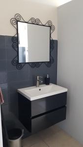 ein Bad mit einem Waschbecken und einem Spiegel in der Unterkunft AgterdeKoog in De Koog