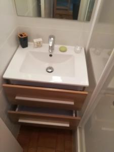 ein weißes Waschbecken im Bad mit Spiegel in der Unterkunft Cap D 'Agde Studio cabine 5 personnes, vue chenal in Cap d'Agde