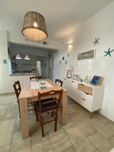 ガラトーネにあるLa casa del Soleのキッチン、ダイニングルーム(木製のテーブルと椅子付)