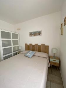 ガラトーネにあるLa casa del Soleのベッドルーム(大きな白いベッド1台、ランプ付)