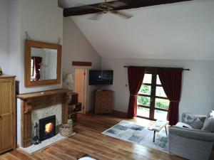 uma sala de estar com lareira e televisão em Catstone Lodge 
