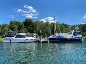 zwei Boote, die an einem Dock im Wasser angedockt sind in der Unterkunft TraumZeitBoot Amavida Yacht auf dem Scharmützelsee Bad Saarow in Bad Saarow