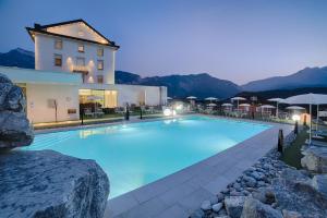 a large swimming pool in front of a building at Bellavista Relax Hotel in Levico Terme
