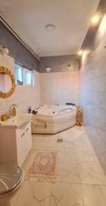 een badkamer met een bad en een wastafel bij Aprtmani "M" br4 in Topola