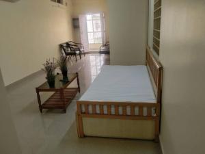 a room with a bed and a table and chairs at Simhagiri Holiday Inn in Visakhapatnam