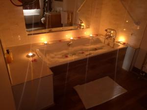 a bathroom with a tub with lights and a mirror at Catstone Lodge 