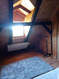 a attic room with a fan and a window at Kuca za odmor Braco in Donji Zvečaj