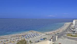 a view of a beach with umbrellas and the ocean at Nafsika Hotel in Rhodes Town