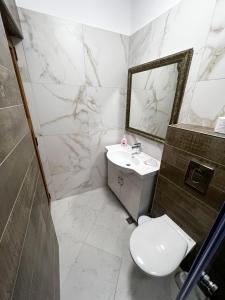 a bathroom with a toilet and a sink and a mirror at Sozopol Apartment with Sea View in Sozopol