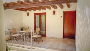 a porch with a table and chairs and a door at Suites la Fe in Oaxaca City