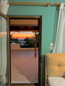 an open door to a balcony with a sunset at KIRKOS “PORTO” in Samothraki