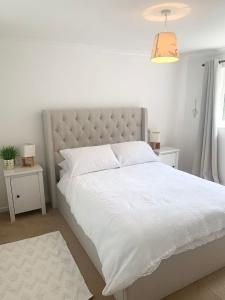 1 dormitorio con 1 cama grande con colcha blanca en Penderels, Willersey, en Broadway