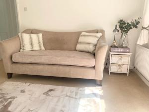 a couch with two pillows on it in a living room at Penderels, Willersey in Broadway
