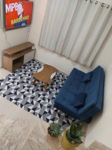 sala de estar con silla azul y TV en Casa Arembepe em frente as piscinas naturais en Arembepe