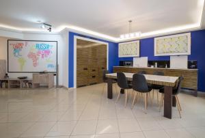 een eetkamer met blauwe muren en een tafel en stoelen bij Spacious Modern Apartments With Great Rooftop View in Athene