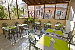 a row of tables and chairs in a room with windows at Nafsika Hotel in Rhodes Town