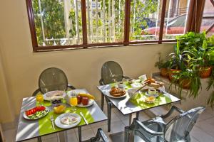 two tables with breakfast food on them in a restaurant at Nafsika Hotel in Rhodes Town