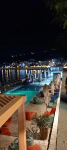 a swimming pool at night next to the water at Apartments Nurkovic in Dobra Voda