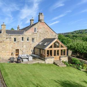 una vista exterior de una casa de piedra con césped en 10 Bed Stunning House in village, with Hot Tub, en Ovingham 89 fotos más