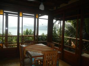 a table and chairs in a room with windows at Holiday home Ilhabela in Ilhabela