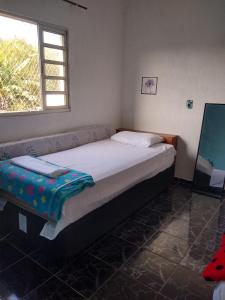 a small bedroom with a bed and a window at Casa de praia em Itanhaem in Itanhaém