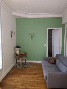 a living room with a blue couch and a table at Trocadéro- 2 pièces lumineux in Paris