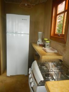 a kitchen with a stove and a white refrigerator at Holiday home Ilhabela in Ilhabela