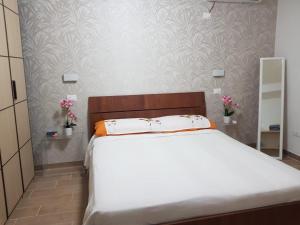 - une chambre avec un grand lit et des draps blancs dans l'établissement Ariosto apartment, à Mondragone