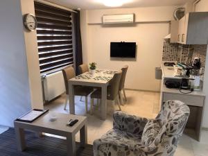 a living room with a table and chairs and a kitchen at Bursa Park Apart Hotel in Bursa